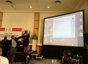 Langa Khumalo, ULPDO director, giving the spellchecker demo, pointing out a detected spelling error in the text. On his left, Mpho Monareng, CEO of PanSALB.